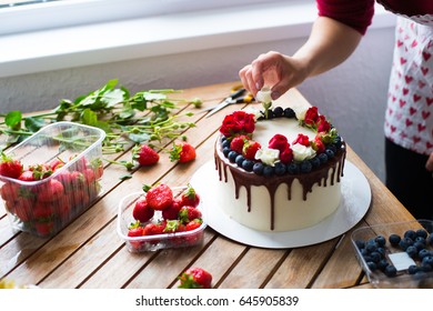 Baker Adding Blueberries To A Cake