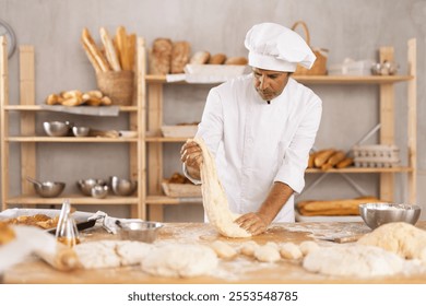 Baker Caucasian guy kneads dough, creates dough from flour, yeast and water for making buns and croissants. Processing of creating croissants in bakery - Powered by Shutterstock