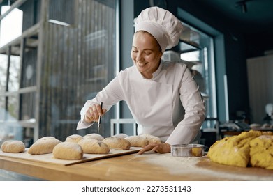 Baker engaged in making of traditional yeast buns with cheese - Powered by Shutterstock