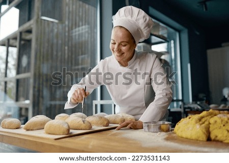 Baker engaged in making of traditional yeast buns with cheese