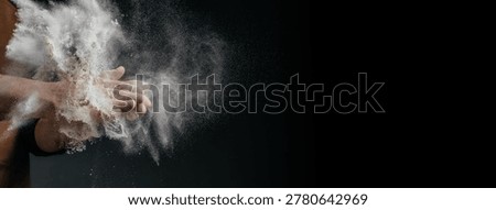 Baker hands covered with flour creating dramatic powder explosion on dark background, artisan bread making concept with copy space.