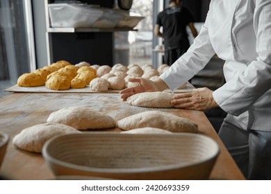 Baker hands preparing formed bread dough for proofing - Powered by Shutterstock