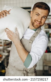 Baker Holding Big Flour Bag At The Kitchen In Bakery House