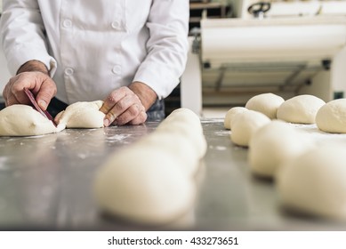 Baker kneading dough in a bakery. Bakery Concept. - Shutterstock ID 433273651