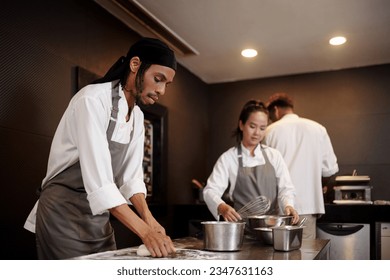 Baker kneading dough to make fresh bread for the restaurant guests - Powered by Shutterstock