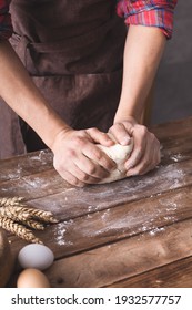 Baker male hand kneading or making dough and bakery ingredients for homemade bread cooking on table. Bakery concept near wall background texture