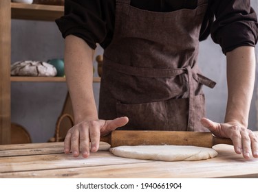 Baker man kneading or making dough or bread cooking. Bakery concept and wooden table background texture