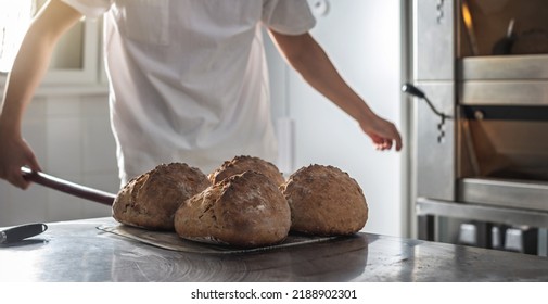 The baker is a man in the process of baking bread. Production of bakery products as a small business.