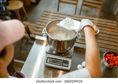 Baker Pours White Flour Into Container To Weigh On Digital Scales In Workshop