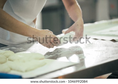 Baker preparing bread. Close up of hands kneading dough. Bakery concept.
