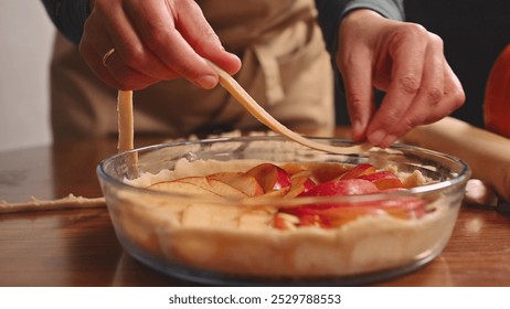 Baker preparing homemade apple pie with fresh red apple slices - Powered by Shutterstock