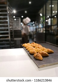 Baker is presenting freshly baked bread on tray