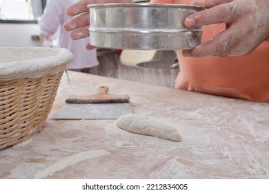 Baker sifts flour over brown bread. Sao Paulo city, Brazil - Powered by Shutterstock