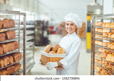 A Baker Woman Holding A Basket Of Baked In Her Hands At The Bakery