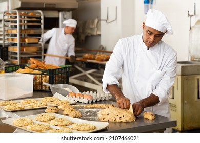 Baker at work - making sweet buns with dough and eggs - Shutterstock ID 2107466021