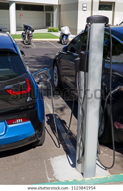 BAKERSFIELD, CA - JUNE 28,\
2018: Electric vehicle charging stations are becoming more common.\
Employees at this firm are replenishing their batteries while they\
work.