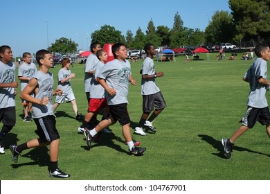 BAKERSFIELD, CA - JUNE 9: Boys Sprint To Get In Shape For The Golden Empire Youth Football Camp At Bakersfield Community College On June 9, 2012,  In Bakersfield, California.