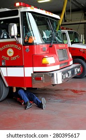 BAKERSFIELD, CA - MAY 21, 2015: A Fireman Does Maintenance Work Under Truck #215 At The Central Fire Station.