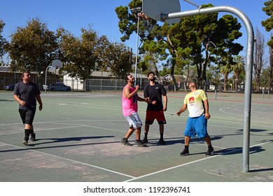 BAKERSFIELD, CA - SEPTEMBER 30, 2018: The Competition Is Fierce As Local Men Engage In A Spirited Game Of Pickup Basketball At A Nearby Playground.