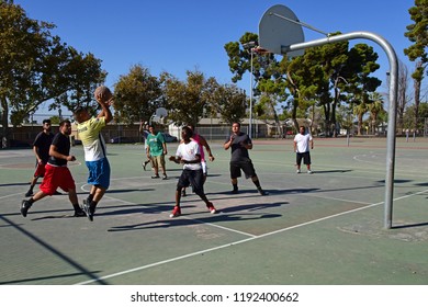 BAKERSFIELD, CA - SEPTEMBER 30, 2018: The Competition Is Fierce As Local Men Engage In A Spirited Game Of Pickup Basketball At A Nearby Playground.