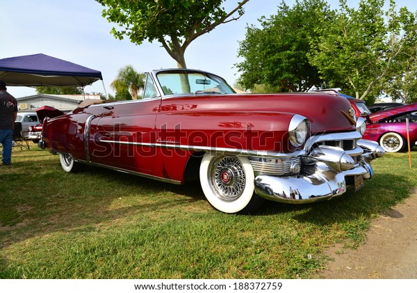 BAKERSFIELD, CA-APRIL 19,\
2014: A very pretty maroon 1953 Cadillac convertible vies for\
attention among all the cars at the Cruisin\' For A Wish Car &\
Motorcycle Show.