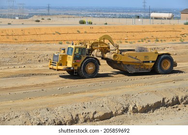 BAKERSFIELD, CA-JULY 18, 2014: A Motor Scraper Helps To Bring The Road Base Up To Grade During The Project To Widen State Route 178.