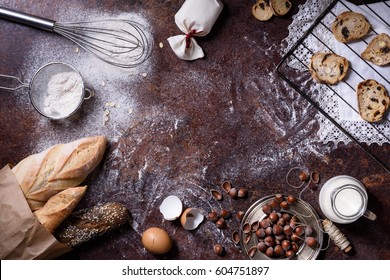 Bakery Background, Baking Ingredients Over Rustic Kitchen Counter Top. Baked Cookies With Hazelnuts, Rye Bread, Milk And Eggs. Top View, Copy Space.