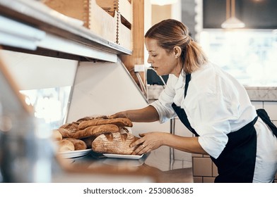 Bakery, busy and woman with bread in cafe for serving food, products and pastry for small business. Restaurant, coffee shop and person for service, help and baked goods for hospitality in store - Powered by Shutterstock