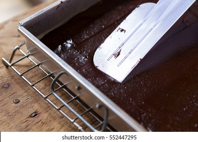 Bakery Chef using rubber scraper making chocolate cake at bakery kitchen
