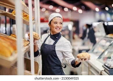 Bakery department seller in supermarket selling fresh buns at supermarket. - Powered by Shutterstock