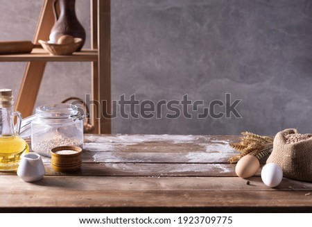 Bakery ingredients for homemade bread cooking or baking on table. Food set at wooden tabletop near wall background texture with copy space. Front view of bakery concept