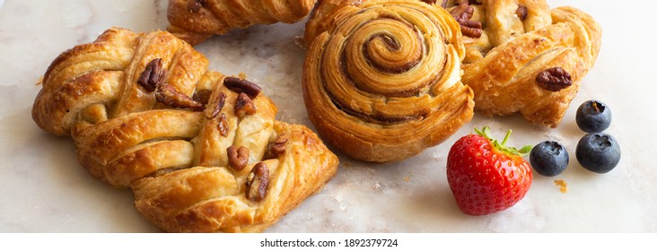 Bakery pastries, strawberries on marble table. Freshly cooked bakery. Home cooked bakery for morning breakfast.