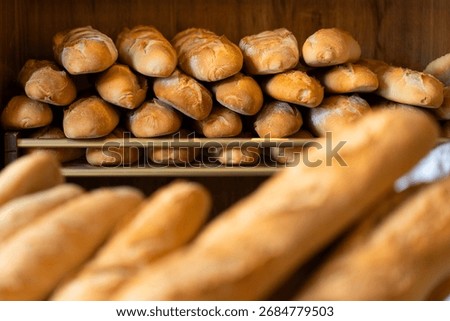 Bakery presenting warm, crusty bread, baguettes, and rolls. Artisan baked goods for sale in a traditional shop