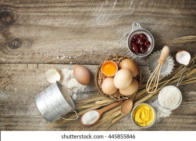 Bakery Recipe Text Background On Rustic Wooden Table Top With Baking Ingredient And Baking Utensils On The Side. Overhead Text Space Image.