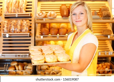 Bakery shopkeeper with a tablet full of doughnuts or Berliners