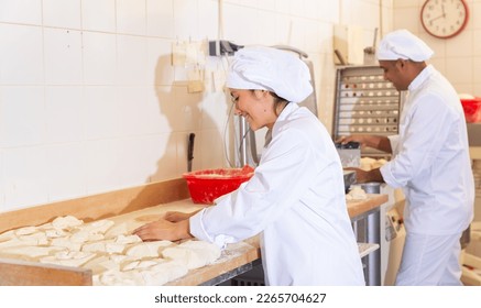Bakery worker preparing raw dough for baking - Powered by Shutterstock