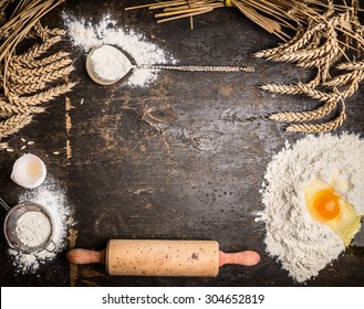 Baking background with bake tools, flour,egg and rolling pin on rustic wooden background, top view