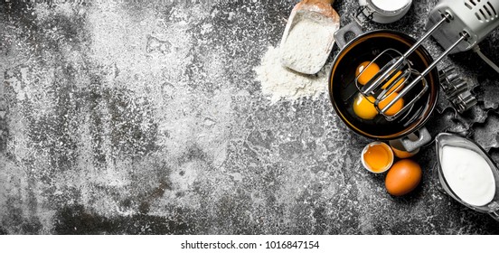 Baking Background. Blend Eggs With A Mixer To Make A Dough. On A Rustic Background.