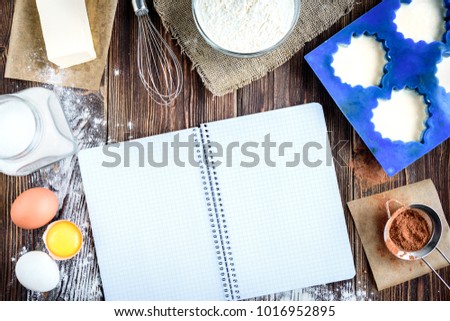 Cooking Ingredients For Cupcakes Or Cookies And Recipe Book On Dark Wooden Background Cooking Ingredients For Cupcakes Or Cookies And Recipe Book On Dark Wooden Background