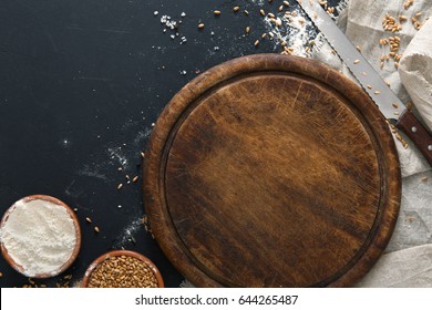 Baking background, flour on board at black. Bakery and home bread making concept. Copy space