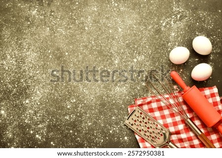 Baking background with flour, roll, eggs and heart shape on gray concrete kitchen table for Valentine's day cooking. Copy space, flat lay.