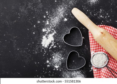 Baking background with flour, rolling pin and heart shape on kitchen black table top view for Valentines day cooking.  Flat lay style.  - Powered by Shutterstock