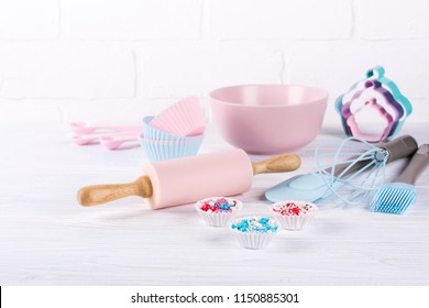 Baking background with kitchen tools: rolling pin, wooden spoons, whisk, sieve, bakeware and shape cookie cutter on white wooden background. - Powered by Shutterstock