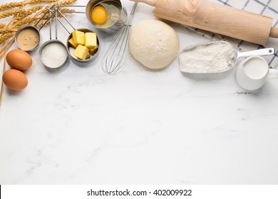 Baking cake, dough recipe ingredients (eggs, flour, milk, butter, sugar) on white table.  - Powered by Shutterstock