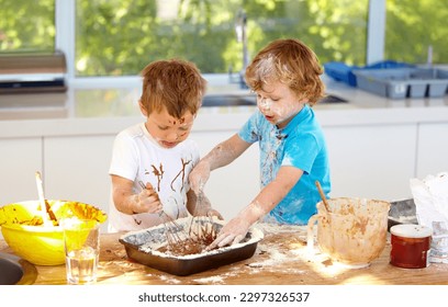 Baking, children and messy friends in the kitchen together, having fun with ingredients while cooking. Kids, food and bake with naughty young brother siblings making a mess on a counter in their home