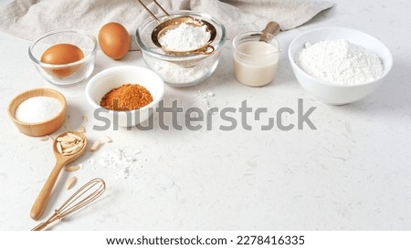 Baking and cooking background, brown sugar, butter, flour, eggs and milk with utensil on marble table with copy space