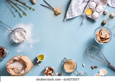 Baking or cooking background frame. Ingredients, kitchen items for baking cakes. Kitchen utensils, flour, eggs, almond, cinnamon, oil. Text space, top view. - Shutterstock ID 614373557