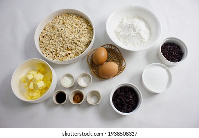 Baking Cooking And Cake Ingredients Flour Eggs Vanilla Powder Bowl Whisk Spatula Butter Cinnamon Powder And Kitchen Textile On White Table Background. Top View. Cookies Pie Or Cake Recipe Mockup