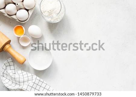 Baking Cooking Ingredients Flour Eggs Rolling Pin Butter And Kitchen Textile On Bright Grey Concrete Background. Top View Copy Space. Cookies Pie Or Cake Recipe Mockup