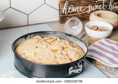 Baking Dish With Baked Apple Pie Stands On Kitchen Counter Next To Ingredients, Cooking Utencils And Wooden Sign Home Sweet Home